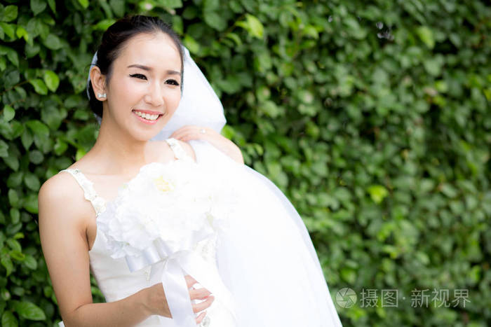 beautiful young woman on wedding day in white dress in the tree 