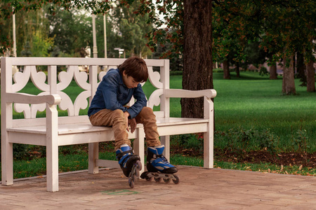 儿童板鞋简笔画一个穿着溜冰鞋的少年坐在公园的长椅上.