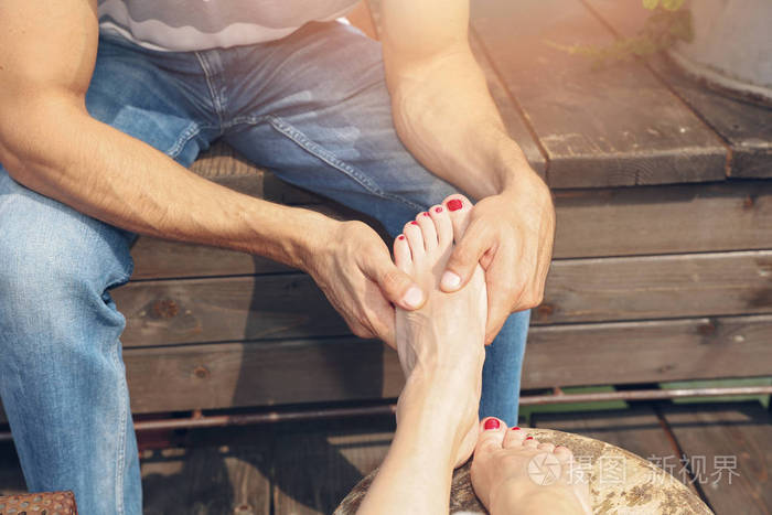 幸福的夫妻目标简单的快乐男人给女人按摩脚两人一起享受时光