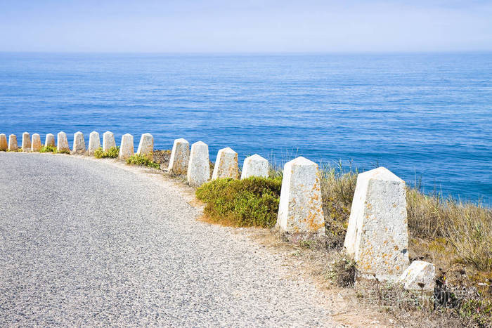 放在海边弯曲道路边缘的路缘石