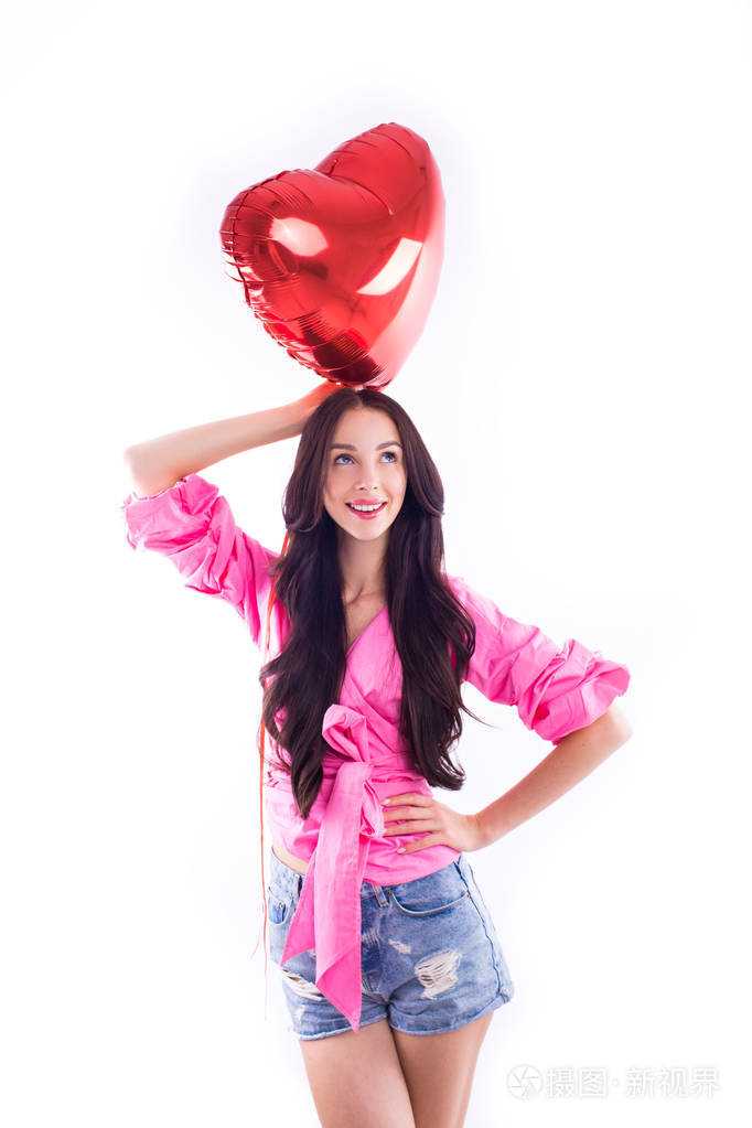 一个活泼开朗的女孩戴着眼镜在一个孤立的白色背景上有一个红色的气球