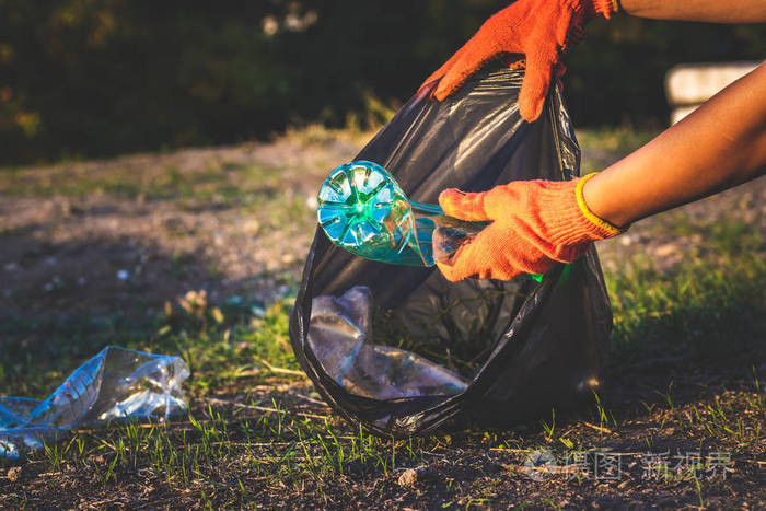 垃圾瓶被捡起来扔进垃圾袋塑料和食物垃圾概念清洁地球收集垃圾避免