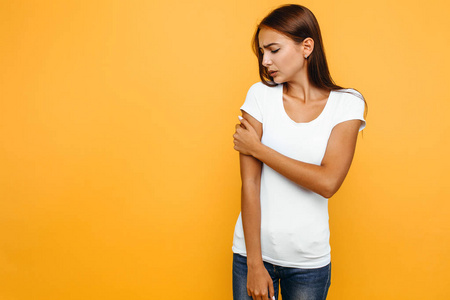 portrait of a sick young woman standing and holding her painful