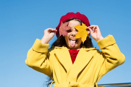 孩子可爱的脸抱着枫叶.小女孩在户外穿秋季服装.阳光明媚,依然温暖.