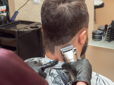 大师手戴黑色橡胶手套.理发店内部.选择性软聚焦.背景模糊.摄影图