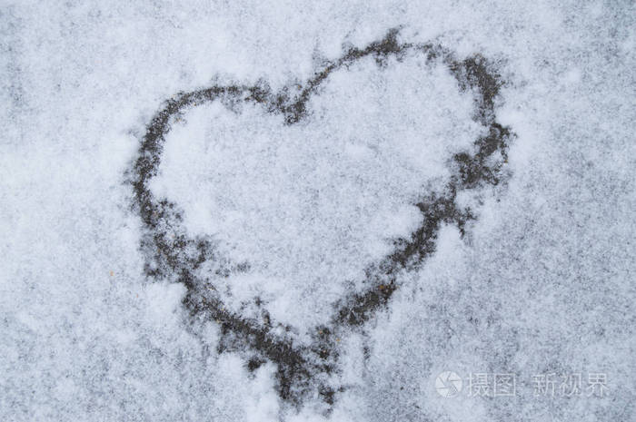 雪地上画着爱的心柔和的蓝色背景情人节