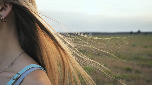 随风飘散文字棕发少女的长发在傍晚的阳光下随风飘散照片