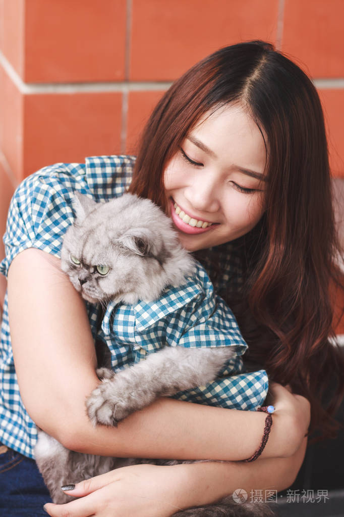 一个年轻的亚洲女人和她的波斯猫玩耍的特写镜头.