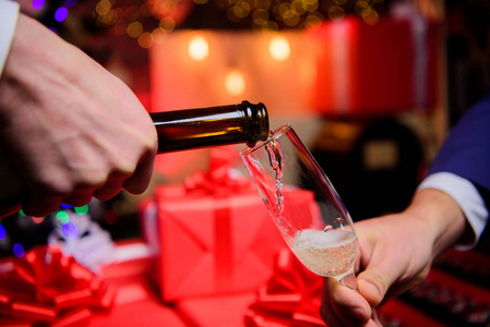 用香槟庆祝新年.双手将香槟倒入优雅的圣诞装饰玻璃背景.干杯概念照片