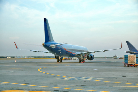 侧窗现代客机停在机场空侧停机坪的候机楼大门上,飞机部件特写喷气
