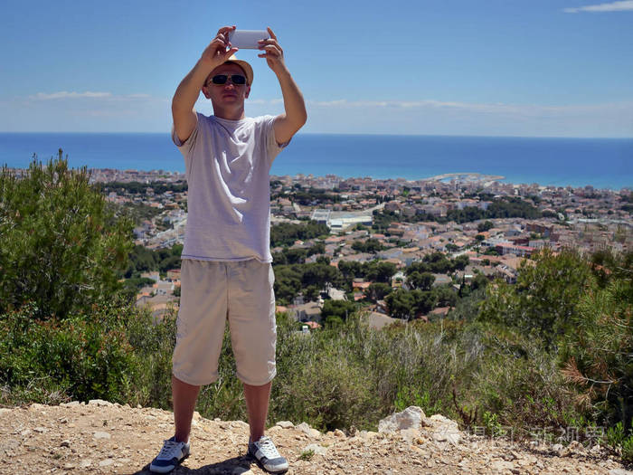 年轻男游客在海边的村庄里自拍