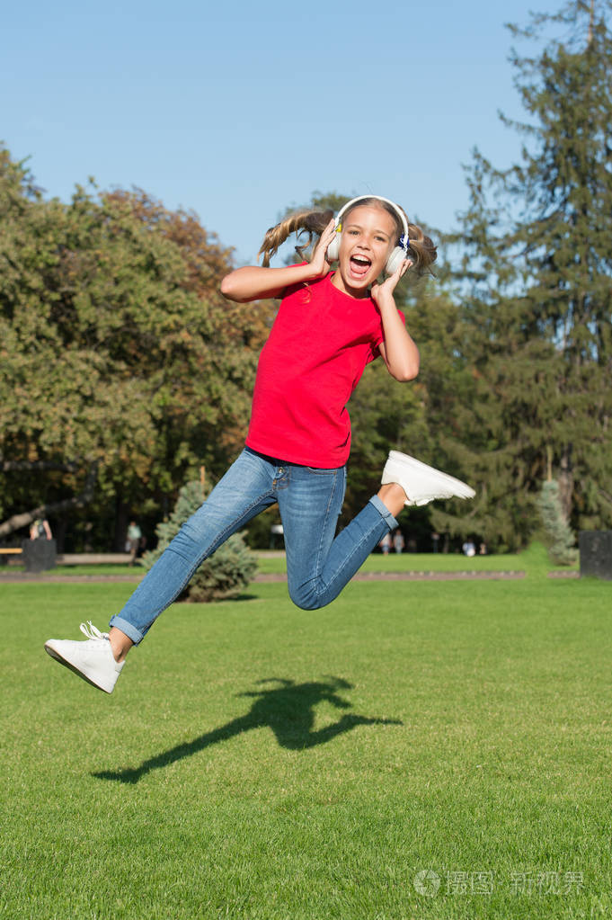 孩子很高兴无线耳机跳舞跑步跳跃.立体声耳机.使用现代科技的孩子.