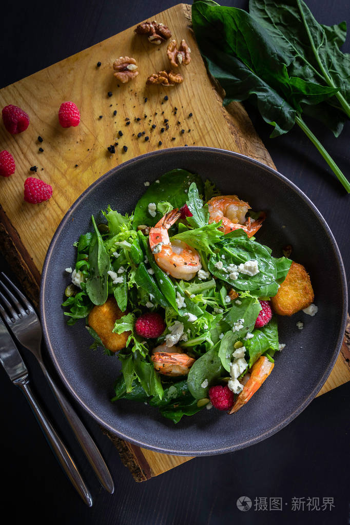 tiger prawn salad with brie cheese, raspberries, walnut. wooden