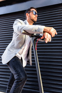 穿着得体,骑着电动车在街上用手机聊天,背景是一个黑色的盲人照片