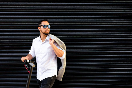 盲人手机一个拉丁成年男子,戴着墨镜,穿着得体,骑着电动车在街上用