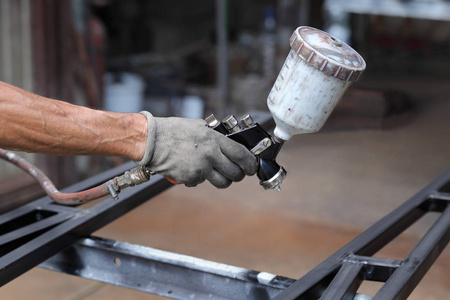 工人用气刷油漆金属照片