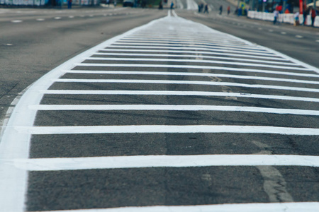 黑色实线道路上有两条实线.沥青上有两条白色条纹.照片