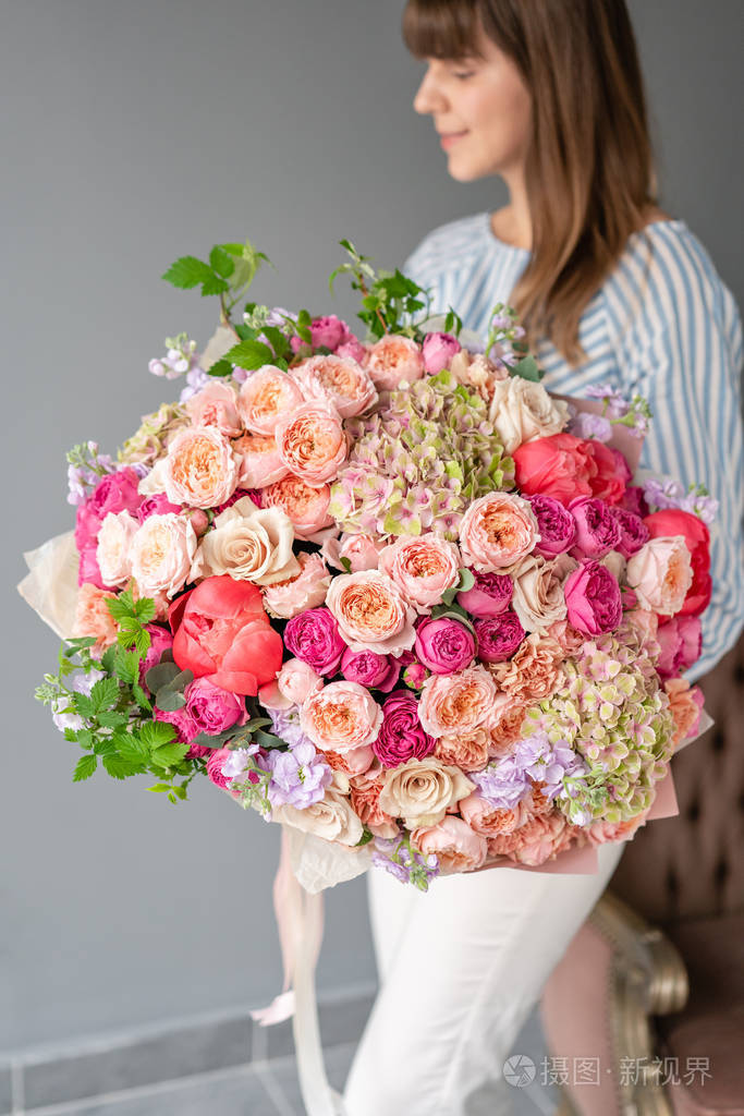 一大束漂亮的混合花在女人手里花店概念美丽的鲜切花束送花