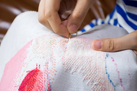 用针做十字绣的女用手.照片