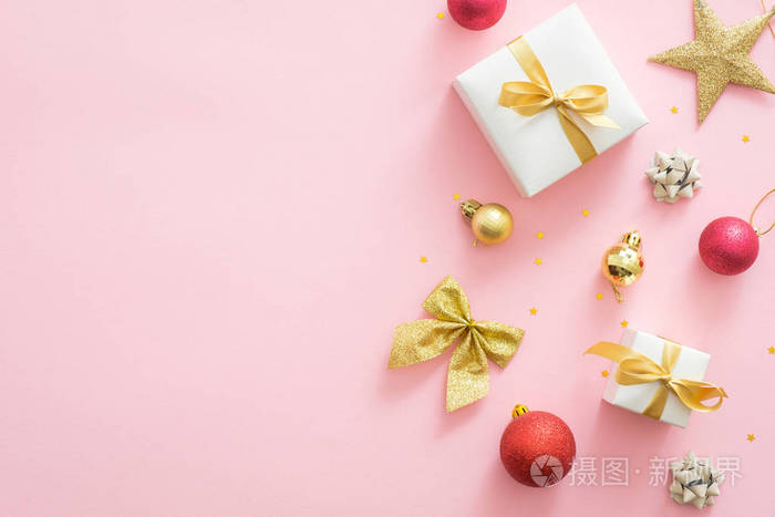 粉红色圣诞背景与礼品盒,金饰品,星星,蝴蝶结,圣诞装饰品.