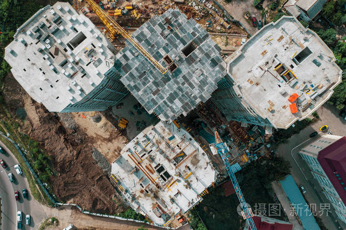 现代混凝土建筑施工现场鸟瞰图配有工业机械设备起重机工人无人机照片