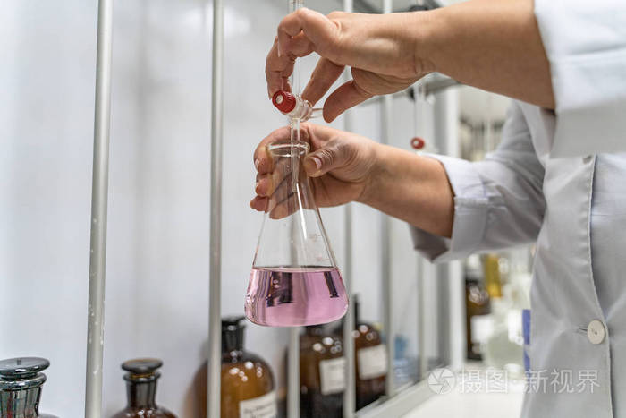 实验室烧杯在测试化学反应实验室工作人员检查纯净饮用水是否有杂质