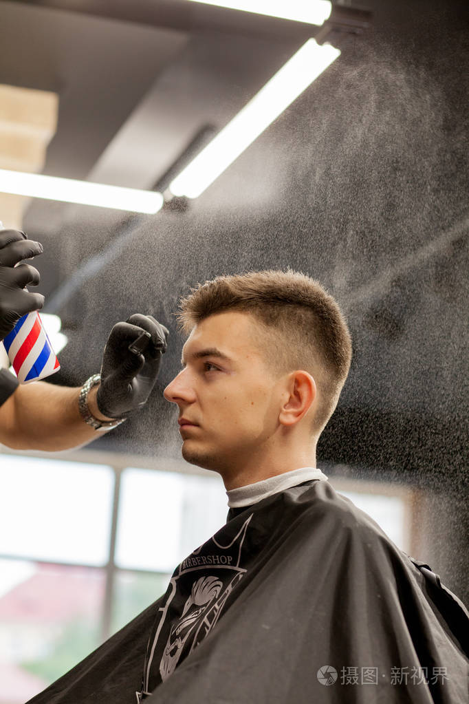 现代理发店的野蛮人理发师使发型成为男人美发师用理
