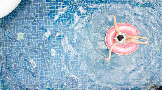 一个女人坐在水环上,漂浮在水上照片