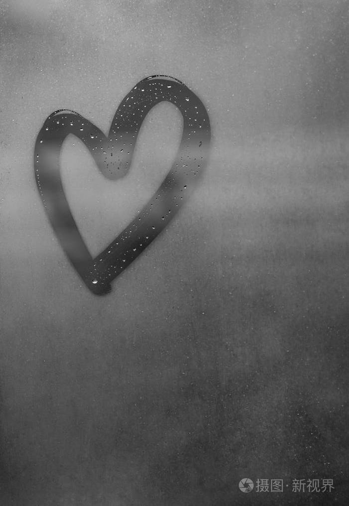 上面有许多水滴,在潮湿的灰色秋雾玻璃上用手工刻字"心与爱"