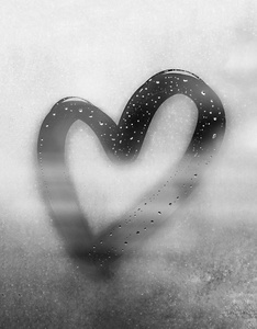 灰色的心画在出汗的玻璃上,上面有许多水滴,在潮湿的灰色秋雾玻璃上用