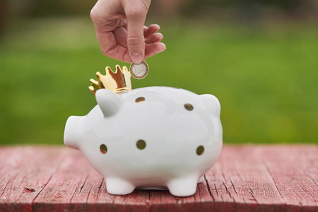 这个女孩在存钱罐里放了1欧元.女孩为梦想存钱.投资,储蓄.照片