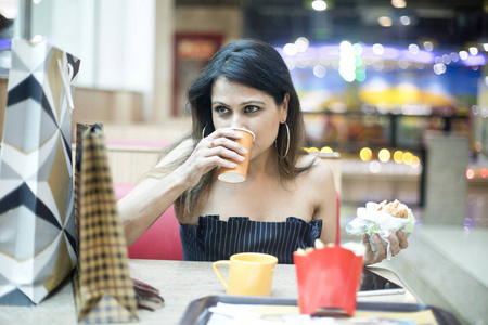 在商场购物后吃喝的女人图片