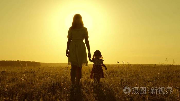 手一个幸福的家庭在傍晚走出小镇母亲和婴儿正在公园里休息孩子和妈妈