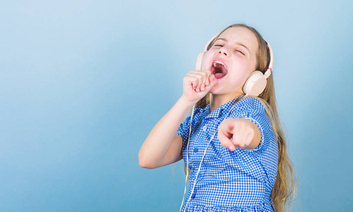 可爱的业余卡拉ok歌手蓝色背景.可爱的小孩在唱歌.