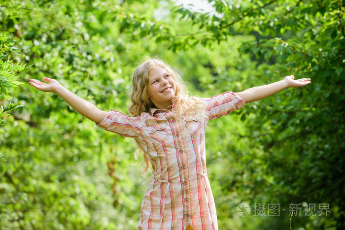 孩子微笑女孩美丽的长卷发自然背景.呼吸新鲜空气.好心情.暑假.