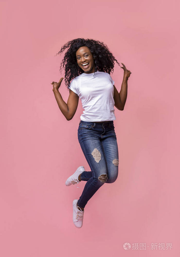 非洲裔美国人快乐的女士跳起来并做手势表示和平