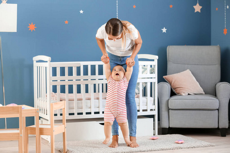 用手握住父母教孩子走路卡通妈妈教孩子走路妈妈教婴儿在街上散步.