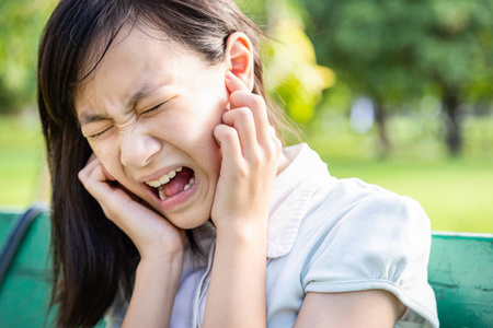 烦躁的女人用食指捂住耳朵感到受伤耳朵疼痛疼痛耳炎噪音大,音乐嘈杂