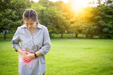 女性患者胃痛感觉急性疼痛,阑尾炎症状,肠道问题在室外公园,保健理念