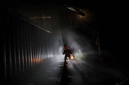 一个可怕的儿童鬼魂的恐怖场景,可怕的娃娃剪影在黑暗的雾背景和灯光.