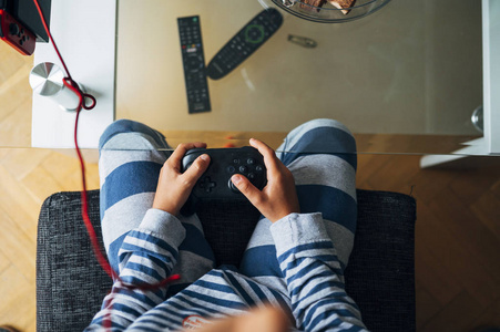 不认识的孩子在家里玩电子游戏机照片