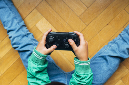 不认识的孩子在家里玩电子游戏机照片