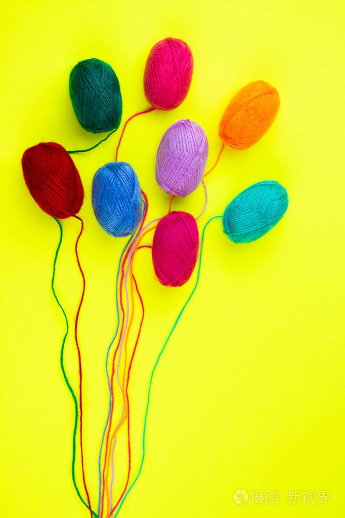 黄色背景上孤立的彩色毛线球
