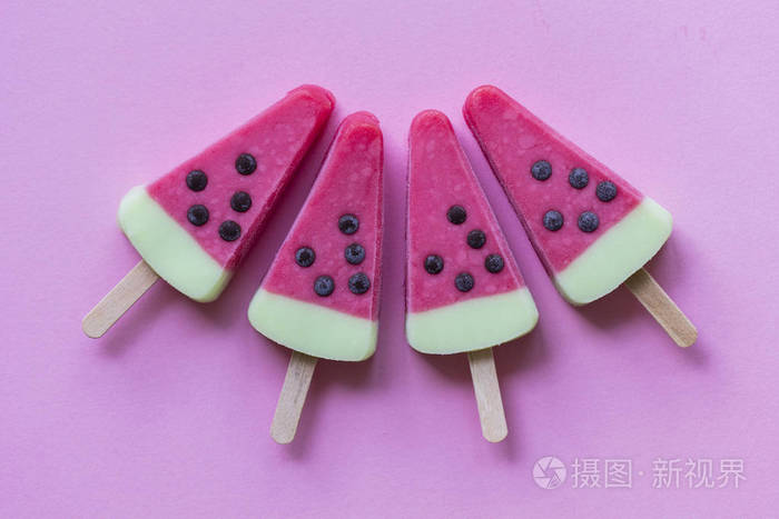 淡粉色背景上的西瓜形状的夏季冰棒