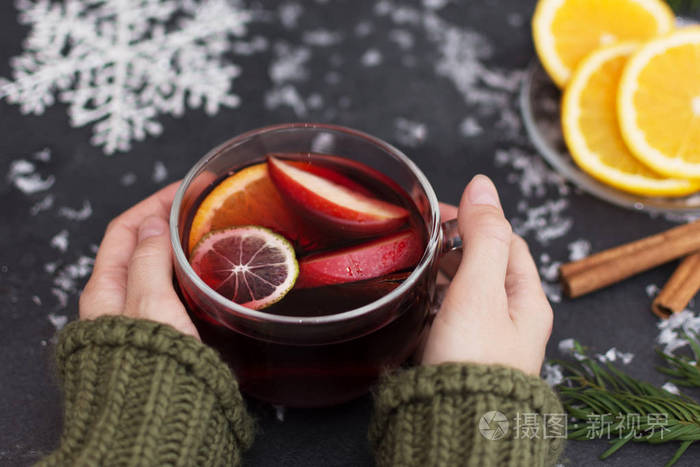一个女人手里拿着一杯热腾腾的圣诞酒特写