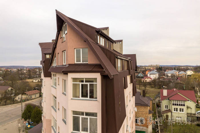 有许多窗户和金属板屋顶的高层公寓楼