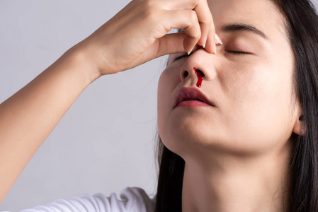 流鼻血,一个流着血的年轻女人.医疗保健和医疗理念.照片
