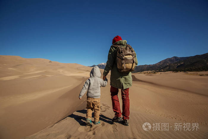 一个男人和他的儿子在沙漠里徒步旅行