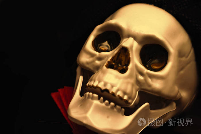 令人毛骨悚然的笑脸金色骷髅头特写黑色背景复制空间死亡和神秘概念