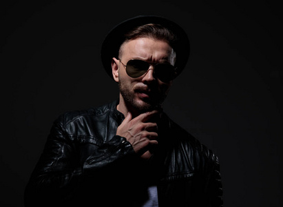 穿着皮夹克,帽子和太阳镜的酷骑手照片